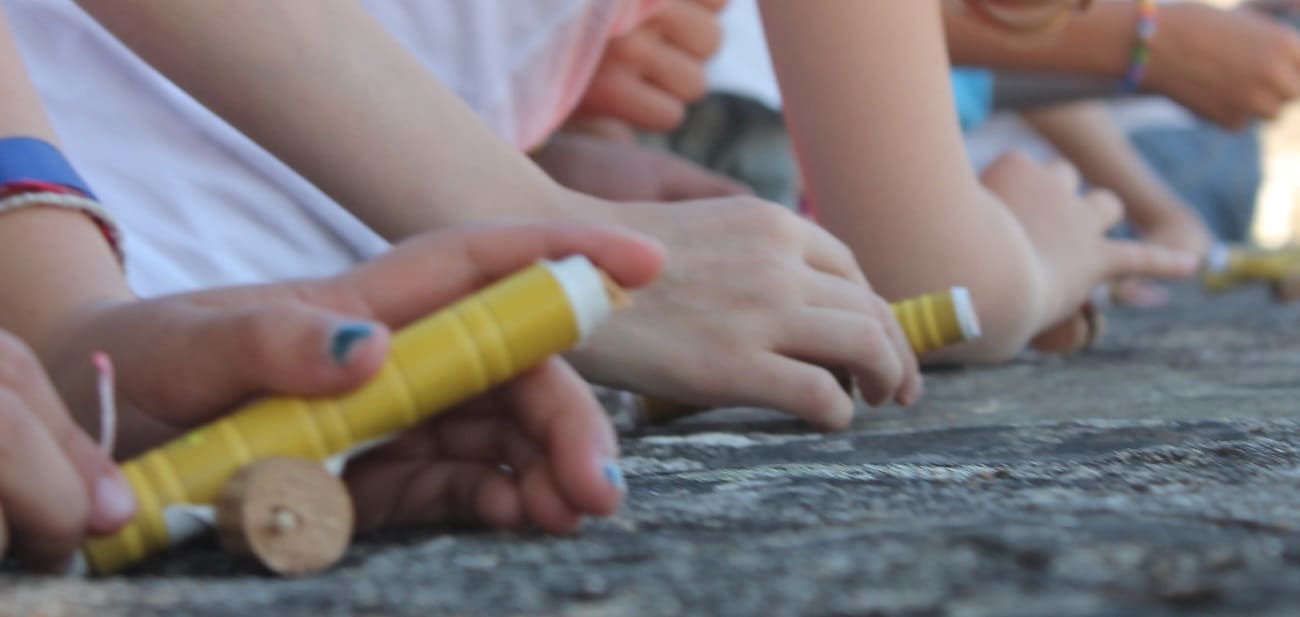 alignement de plusieurs canons de papier, mains d'enfants eu second plan
